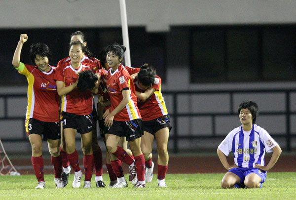 18일 수원종합운동장에서 벌어진 대교눈높이 2009 WK-리그 수원FMC(수원시설관리공단)과 서울시청의 경기에서 서울시청 정원정이 경기종료 직전 결승골을 넣고 동료들과 환호하는 사이 수원FMC 정성은(오른쪽)이 그라운드에 허탈하게 앉아 있다./연합뉴스