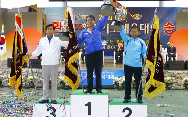 제55회 도체육대회 시상식에서 수원시체육회 윤태헌 사무국장이 우승기와 우승컵을 들고 기뻐하고 있다.