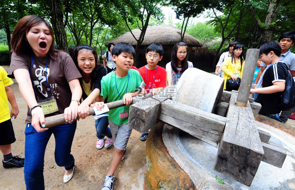  15일 용인 한국 민속촌에서 결혼 이민자 가족들의 사회, 문화적 적응을 돕기 위한 ‘2009 한국 문화체험 캠프’가 열려 참가자들이 연자방아를 돌려보며 전통문화를 체험하고 있다.
