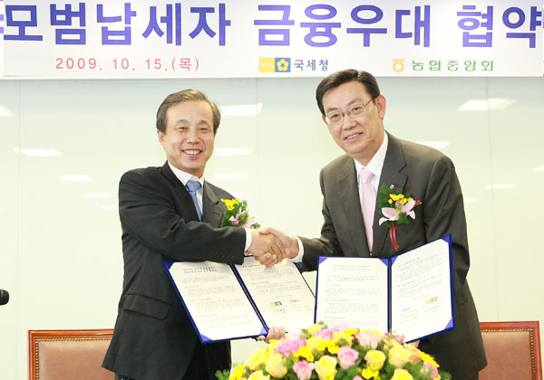 이현동 국세청 차장(왼쪽)과 김태영 농협신용 대표이사가 15일 농협중앙회 본점에서 모범 납세자 금융우대을 위한 업무협약을 체결한 뒤 악수를 나누고 있다. /사진=중부지방국세청 제공