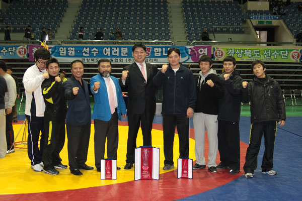 제3회 전국레슬링종합선수권대회 남자일반부 그레코로만형에서 2년 연속 종합우승을 차지한 수원시청 선수단이 우승트로피를 앞에 두고 대한레슬링협회 임원들과 파이팅을 외치고 있다./제공=수원시청 레슬링선수단