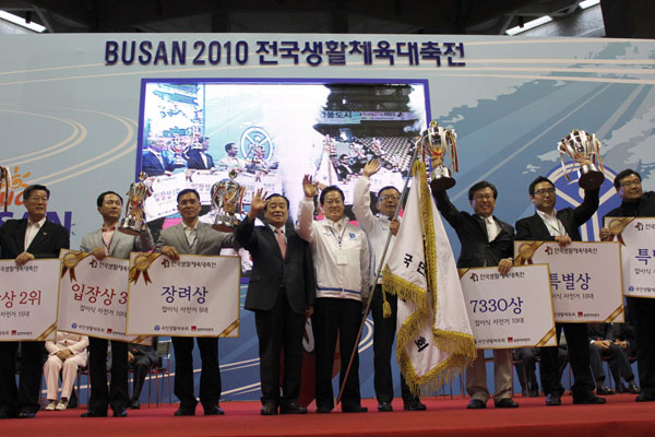 13일 부산 사직체육관에서 열린 2010 전국생활체육대축전 시상식에서 10년 연속 최다 종목우승을 차지한 경기도선수단을 대표해 박영표 도생체회 수석부회장(왼쪽에서 5번째)과 오세구 사무처장(왼쪽 6번째)이 국민생활체육회기를 들고 이강두 전국생활체육회장(왼쪽 4번째)과 함께 기념촬영을 하고 있다./사진제공=경기도생활체육회