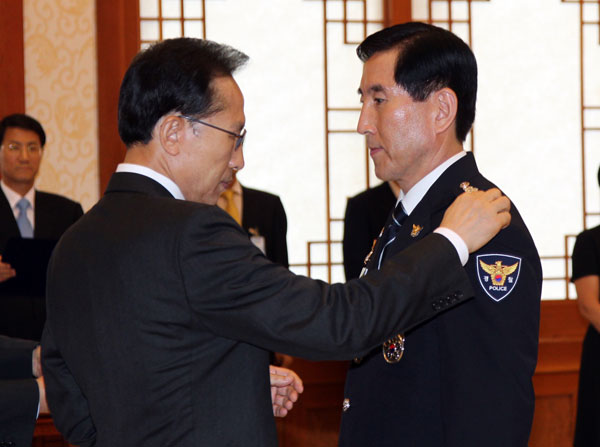 이명박 대통령이 30일 오후 청와대에서 조현오 경찰청장에게 임명장을 주기에 앞서 계급장을 달아주고 있다./연합뉴스
