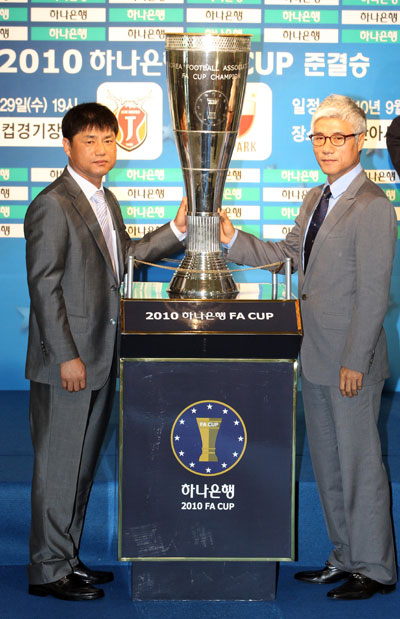 13일 오후 서울 신문로 축구회관에서 열린 2010 하나은행 FA컵 준결승 대진추첨에서 결승 진출을 놓고 맞붙게 된 수원 블루윙즈 윤성효 감독과 제주 유나이티드 박경훈 감독이 우승컵을 옆에 두고 포즈를 취하고 있다. /연합뉴스