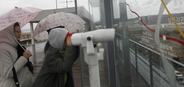 남북장성급군사회담 북측 단장이 남측에 “심리전 행위가 계속된다면 임진각을 비롯한 반공화국 심리모략 행위의 발원지에 대한 우리 군대의 직접조준격파사격이 자위권 수호의 원칙에서 단행될 것”이라는 통지문을 보낸 가운데 27일 파주 임진각을 찾은 관광객들이 망원경으로 북측 지역을 살펴보고 있다. /연합뉴스