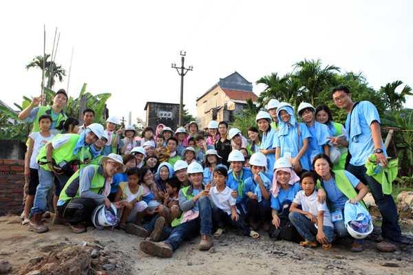 베트남에서 해외 봉사활동을 펼치고 있는 포스코건설의 해피빌더가 지역 아이들과 피곤함도 잊은채 웃으며 기념촬영을 하고 있다.