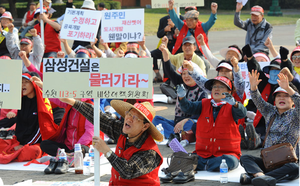 수원시 권선 113-6구역 재개발 비상대책위원회 소속 주민들이 10일 수원 올림픽공원앞에서 재개발 반대 결의대회를 갖고 재개발을 중단하라는 구호를 외치고 있다./노경신기자 mono316@