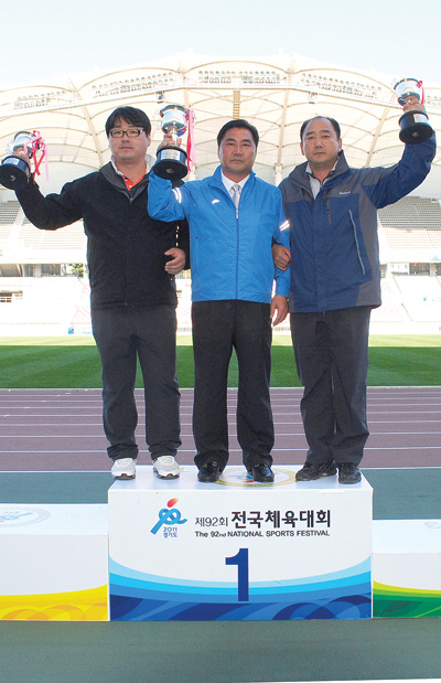 제92회 전국체육대회 폐막을 하루 앞둔 11일 고양종합운동장에서 끝난 육상종목에서 역대 처음으로 종목우승 20연패를 달성한 유정준 총감독(경기도육상경기연맹 전무이사·가운데)이 우승컵을 들고 기뻐하고 있다. /특별취재팀