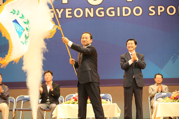 13일 평택 청소년문화센터 체육관에서 열린 제58회 경기도체육대회 폐회식에서 2013년 제59회 경기도체육대회를 유치한 김규선 연천군수가 이재율 도 경제부지사로부터 전달받은 대회기를 흔들고 있다./제공=경기도체육회