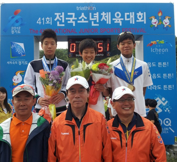 경기체중 한용규 교장(앞줄 가운데)이 지난 26일 이천 설봉공원에서 열린 제41회 전국소년체육대회 트라이애슬론에서 2관왕에 오른 김정현(뒷줄 가운데)을 격려한 뒤 기념촬영을 하고 있다./제공=경기체육중학교