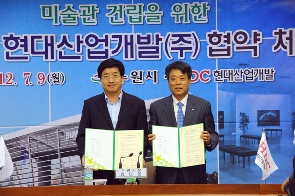 미술관 건립을 위한 수원시와 현대산업개발(주)의 협약체결식이 9일 오전 수원시청 상황실에서 열린가운데 염태영 수원시장(사진 왼쪽)과 박창민 현대산업개발(주) 대표이사가 체결을 마친 후 기념촬영을 하고 있다.