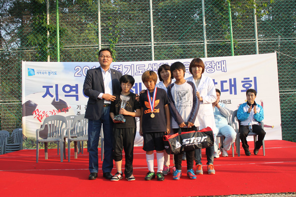 13일 수원월드컵경기장 에스빌드 풋살파크에서 열린 2012 경기도생활체육회장배 지역아동센터 풋살대회에서 초등부 우승을 차지한 가람2클럽 선수들이 한규택 도생활체육회 사무처장(맨 왼쪽)과 기념촬영을 하고 있다./제공=경기도생활체육회