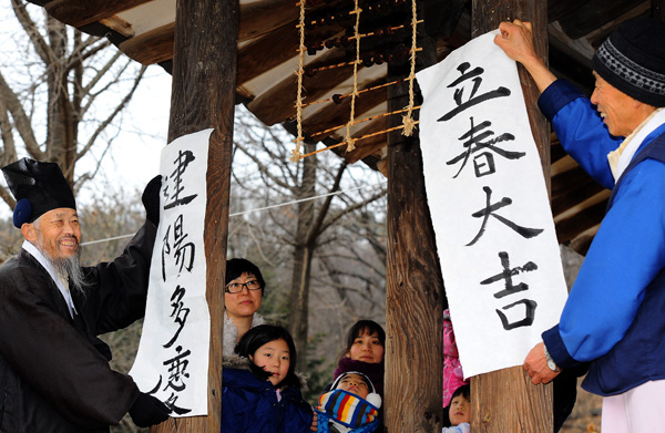  봄에 들어선다는 절기상 입춘(立春)을 하루 앞둔 3일 용인시 기흥구 한국민속촌에서 민속촌 관계자들이 한옥 기둥에 입춘이 되어 크게 길하다는 뜻의 ‘입춘대길’과 따스한 기운이 도니 경사가 많으리라 는 의미를 담은 ‘건양다경’이 쓰인 입춘첩 붙이고 있다.