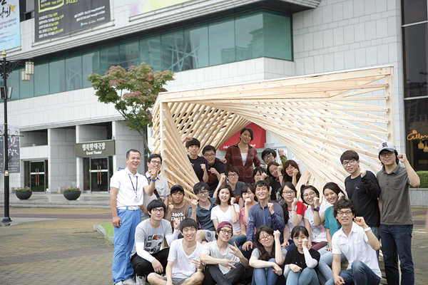 11일 경기도문화의전당 광장에 첫 목조작품 설치를 마친 경희대학교 건축학과 학생들과 전당 관계자들이 기념촬영을 하고 있다.