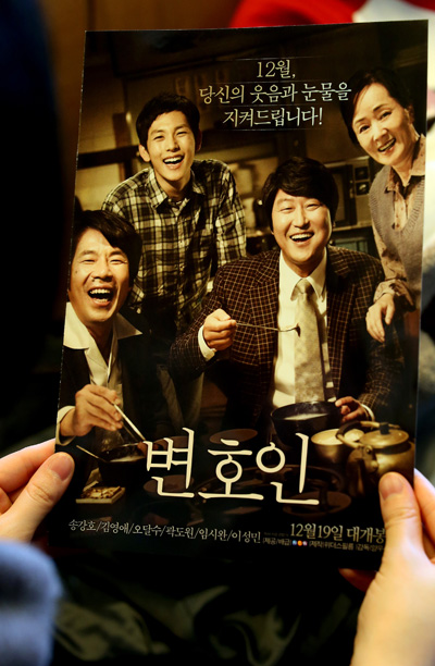 송강호 주연의 '변호인'이 막강한 흥행력으로 개봉 10일만인 28일 누적관객 400만 명을 돌파했다. 지난 29일 오후 서울 광진구 자양동의 영화관에서 한 관객이 변호인 유인물을 살펴보고 있다. /연합뉴스