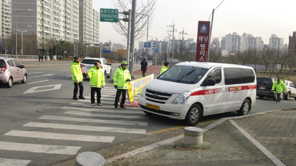 5일 수원시지역자율방재단원들이 서호저수지 주변을 통과하는 자동차를 대상으로 AI방역활동을 펼치고 있다./수원시 제공