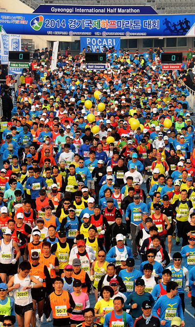23일 오전 수원시 수원종합운동장에서 한국실업육상경기연맹과 경기신문이 공동주최한 ‘2014 경기국제하프마라톤대회’가 열려 참가자들이 힘찬 출발을 하고 있다. /특별취재팀