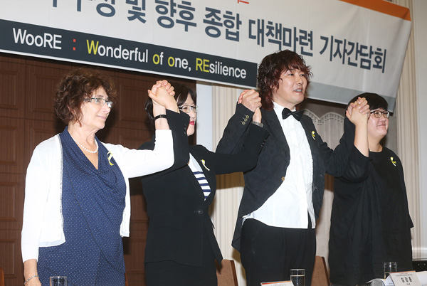 4일 오전 서울 중구 태평로1가 한국프레스센터에서 열린 ‘4.16 세월호 피해자 돕기 WooRE 프로젝트 - 민간 트라우마 힐링조직 구성 및 향후 종합 대책마련 기자간담회’에서 오라 국제민간구호기관 israAID 교수(왼쪽부터), 김선현 차병원 미술치료클리닉 교수, 가수 김장훈, 안익선 굿피플 사무총장이 손을 잡고 있다. /연합뉴스