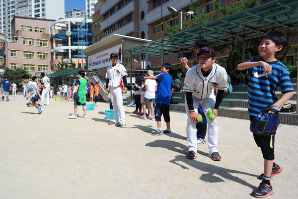 7일 용인 효자초등학교에서 진행된 프로야구 KT 위즈 ‘새싹 마케팅’에서 장현진(우측)과 이상원이 효자초 학생들에게 캐치볼을 가르치고 있다./KT위즈 제공