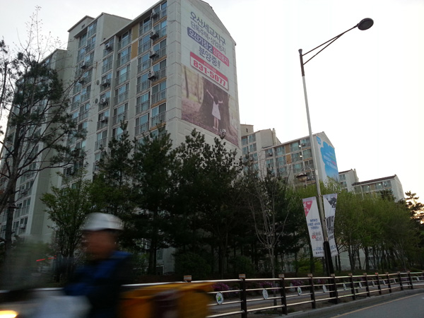 화성시 반송동의 한 아파트 단지 2개 동 벽면에 수개월째 분양홍보 관련 대형 불법현수막들이 버젓이 부착돼 있다./이상훈기자 lsh@