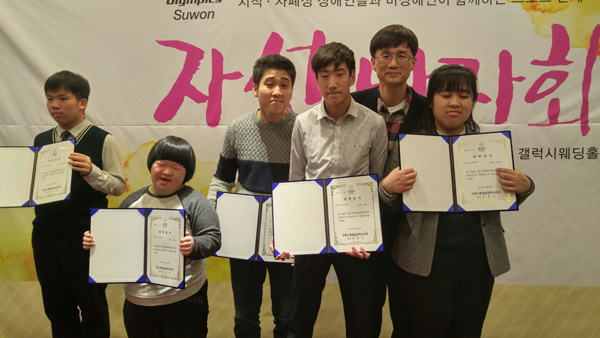 3일 갤럭시웨딩홀에서 열린 ‘지적·자폐성장애인을 위한 자선 바자회’에서 성경기 수원스페셜올림픽코리아회장(오른쪽 두번째)이 장학금을 전달한 뒤 기념촬영을 하고 있다./수원시장애인체육회 제공