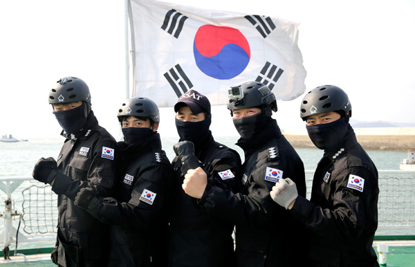 국민안전처의 태극기 부착 지시에 따라 인천해경의 기동복에 태극기가 부착된다. 사진은 해경 대원들이 태극기를 부착한 후 사진을 찍고 있는 모습. /인천해경 제공
