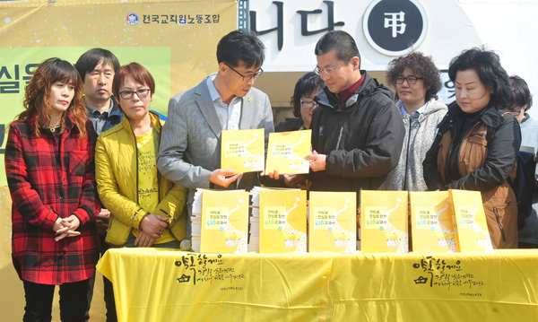  세월호 참사2주기를 맞아 전국교직원노동조합이 ‘기억과 진실을 향한 4·16교과서’를 발간한 가운데 22일 안산시 세월호 희생자 정부합동분향소에서 헌정식이 열려 변성호 전교조 위원장(오른쪽)이 유가족에게 교과서를 전달하고 있다./이진우기자 poet11@