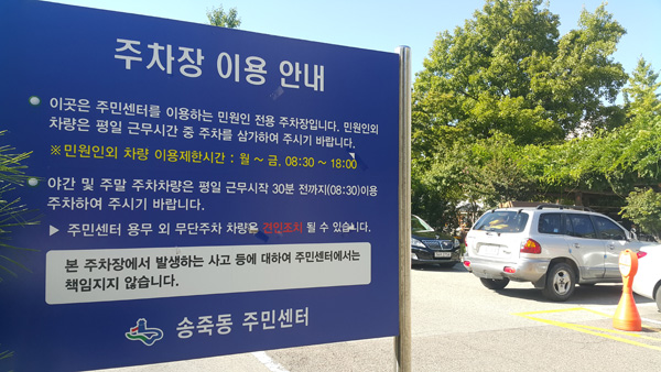 21일 수원시 송죽동 주민센터 청사 주차장 입구에 민원인 외 외부차량의 출입을 제한한다는 내용과 함께 주차장 이용 시간이 게재된 팻말이 세워져 있다. /김홍민기자 wallace@
