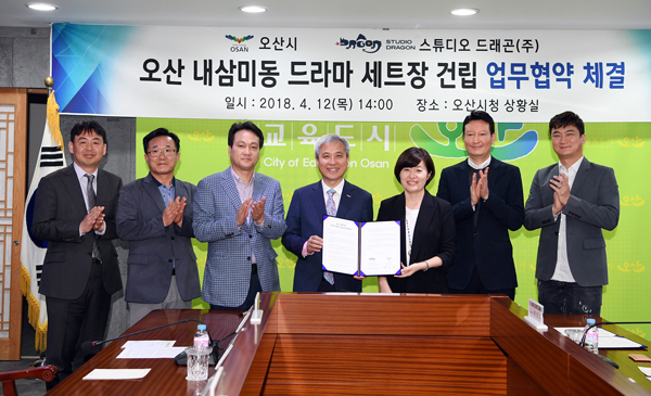오산시와 스튜디오 드래곤 관계자들이 12일 블록버스터급 사전 제작 드라마인 ‘아스달 연대기’(가제)의 드라마 세트장 건립을 위한 업무협약을 체결한 뒤 기념촬영을 하고 있다. /오산시 제공