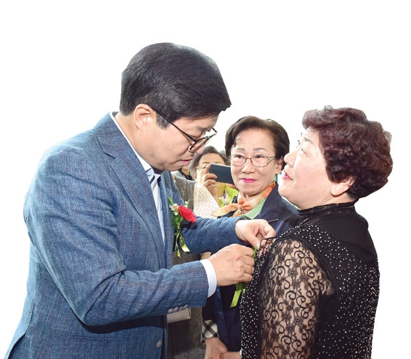 5월 어버이날 기념행사에서 어르신들에게 카네이션을 달아주고 있는 염태영 수원시장.