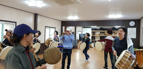 마을주민들이 한 곳에 모여 풍물놀이를 즐기고 있다.