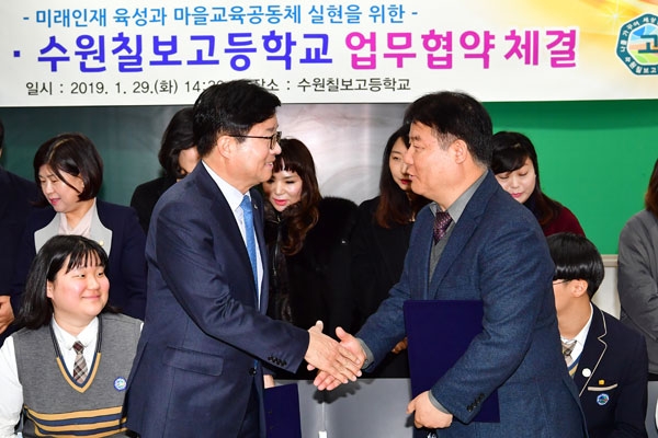 염태영 수원시장(왼쪽)과 김영창 수원칠보고등학교 학교장이 지난달 29일 학교시설 개방 관련 협약 체결 후 악수를 하고 있다./수원시 제공