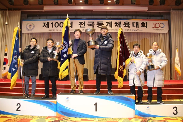 지난 22일 강원도 평창군 용평리조트 드래곤밸리호텔 그랜드볼룸에서 열린 제100회 전국동계체육대회 시상식에서 종합우승 17연패를 달성한 박상현 경기도선수단 총감독(오른쪽 세번째)과 박승생 도체육회 경기훈련과장(왼쪽 세번째)이 우승컵과 우승기를 들고 기념촬영을 하고 있다. /경기도체육회 제공
