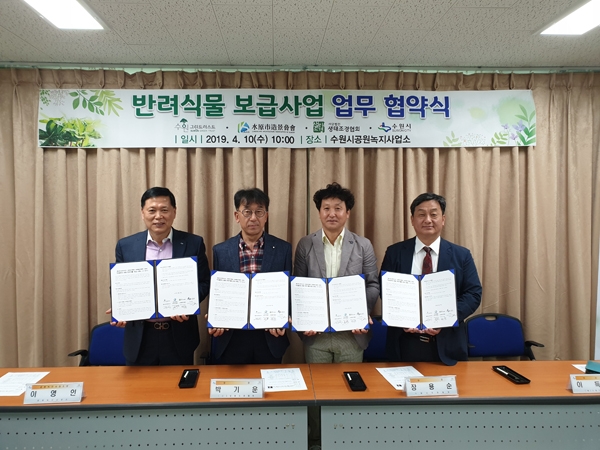 (왼쪽부터) 이영인 수원시 공원녹지사업소장, 박기운 (사)생태조경협회장, 장용순 수원시조경협회장, 이득현 (재)수원그린트러스트 이사장이 ‘미세먼지 대응 반려식물 보급 사업’을 위한 협약을 체결하고 다함께 기념촬영을 하고 있다. /수원시 제공