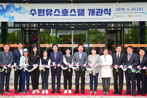 염태영 수원시장(왼쪽 여섯 번째), 김진표 국회의원(왼쪽 여덟 번째), 조명자 수원시의장(왼쪽 아홉 번째)가 수원시 청소년을 비롯한 관계자들과 함께 수원유스호스텔 개관을 축하하고 있다./수원시 제공
