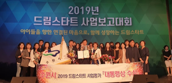 권찬호 수원시 복지여성국장(앞줄 가운데)을 비롯한 수원시 관계자들이 ‘2019년도 드림스타트 사업 성과평가’에서 ‘대도시 기초단체부문’ 대통령상 기관표창을 받은 뒤 다함께 기념촬영을 하고 있다. /수원시 제공