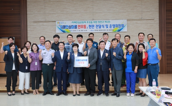 최혜옥 장안구보건소장(앞줄 왼쪽 여섯 번째), 전교영 연무동장(앞줄 왼쪽 일곱 번째)을 비롯한 관계자들이 연무동 행정복지센터에서 치매안심마을 현판식을 연 뒤 다함께 기념촬영을 하고 있다. /수원시 제공