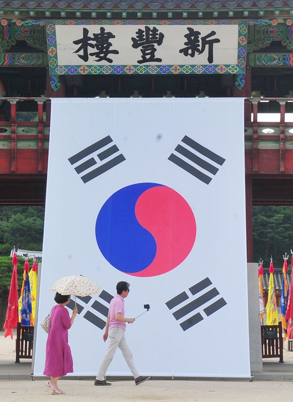 제74주년 광복절을 하루 앞둔 14일 수원시 팔달구 화성행궁에서 시민들이 대형태극기를 배경으로 기념촬영을 하고 있다. /조병석기자 cbs@