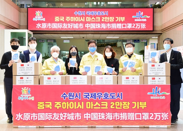 염태영 시장과 수원시 공직자들이 주하이시에서 보낸 마스크 상자를 앞에 두고 기념촬영을 하고 있다./수원시 제공