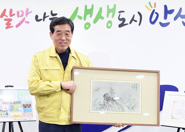 안산시가 최근 단원 김홍도의 작품 ‘여동빈도’와 표암 강세황의 작품 ‘묵포도도’, 김양기의 작품 ‘가응도’ 등을 낙찰받았다. 사진은 윤화섭 시장이 ‘여동빈도’를 들고 있는 모습. /안산시 제공