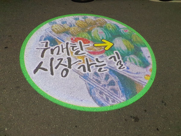 수원시 구매탄시장 도로 위에 비춰지고 있는 로고젝트./영통구청 제공