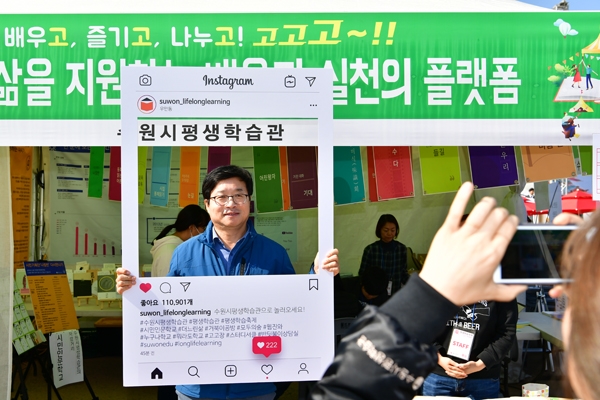 수원시 평생학습축제에 참여한 평생학습관 부스에서 염태영 수원시장이 시민들에게 참여를 독려하는 홍보사진을 찍고 있다./수원시 제공
