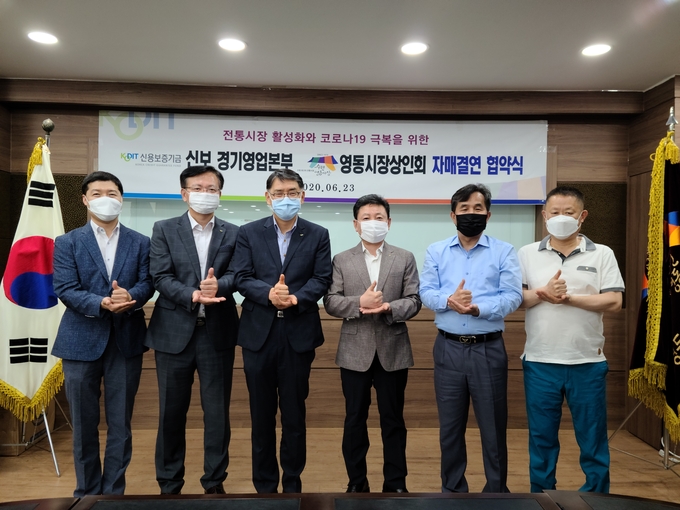 신용보증기금 경기영업본부와 수원 영동시장상인회 관계자들이 23일 자매결연 협약식에서 '덕분에 챌린지'를 진행하고 있다. (사진=신용보증기금 경기영업본부 제공)