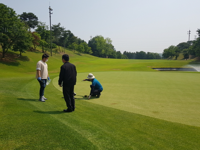 경기도보건환경연구원 관계자가 골프장에서 농약잔류량 검사를 위해 시료를 채취하고 있다.(사진=경기도 제공)