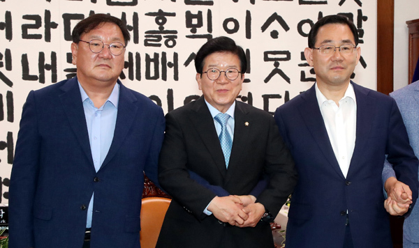 박병석 국회의장(가운데), 더불어민주당 김태년 원내대표(왼쪽), 미래통합당 주호영 원내대표가 28일 국회 의장실에서 원구성 협상을 위해 만나 손을 잡고 기념촬영하고 있다. /연합뉴스