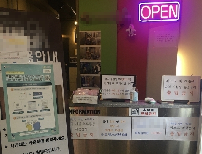 수원시 인계동 소재 한 코인노래방 카운터에 QR코드 전자출입명부 작성 협조 안내문이 붙어 있다. (사진=김민기 수습기자)
