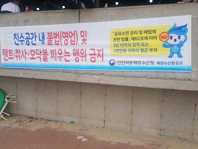 홍보 현수막에 친수공간 내 불법 영업 행위, 텐트, 취사, 모닥불 등을 금지한다는 내용이 담겨 있다.(사진=박건 기자)