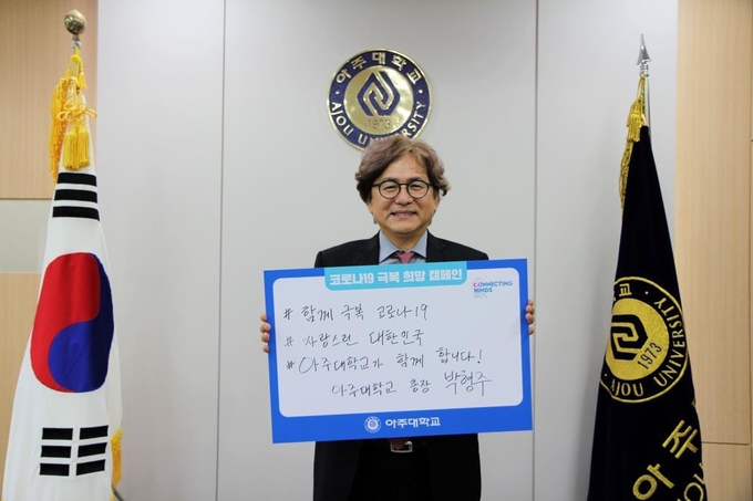14일 박형주 아주대학교 총장이 ‘함께 극복 코로나19, 자랑스런 대한민국, 아주대학교가 함께 합니다!’라는 메시지 푯말을 들고 코로나19 극복을 위한 '희망캠페인 릴레이'에 참가했다. (사진 = 아주대학교 제공)