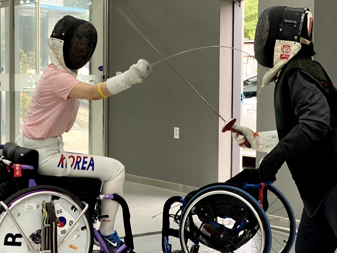 코로나19 이전 gkl휠체어펜싱체육관 상임심판 정경미 선생님과 함께 훈련하는 김선미 선수(왼쪽). (사진=김선미 선수 제공)