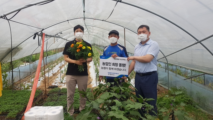 농협자산관리회사 경기동부지사 관게자들이 15일 경기 이천시 부발읍 소재 시설채소 농가를 방문해 '농업인 희망동행 프로젝트'를 실시하고 기념촬영을 하고 있다. (사진=농협자산관리회사 경기동부지사)